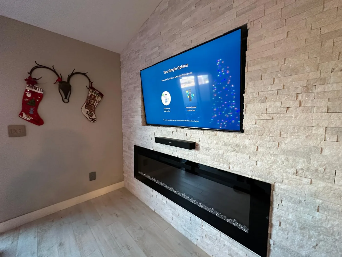 TV and soundbar mounted above a recessed fireplace