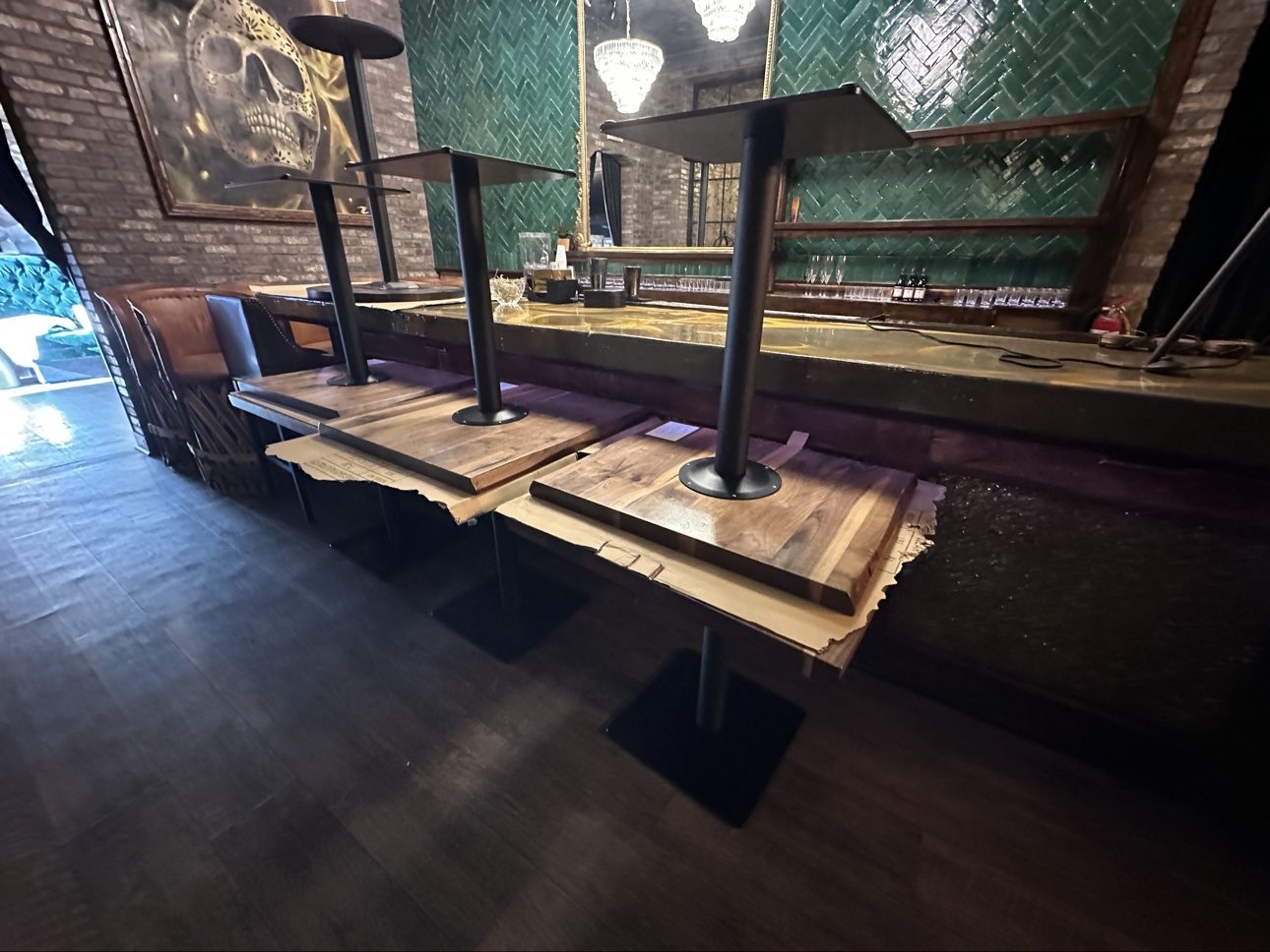Table bases mounted to wooden tabletops in a bar